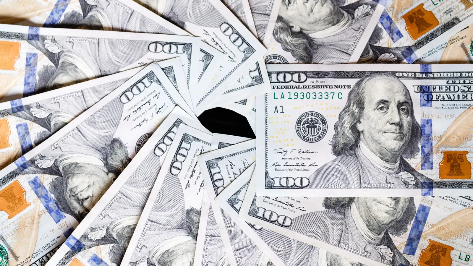 Hundred dollar bills fanned out in a tight spiral.
