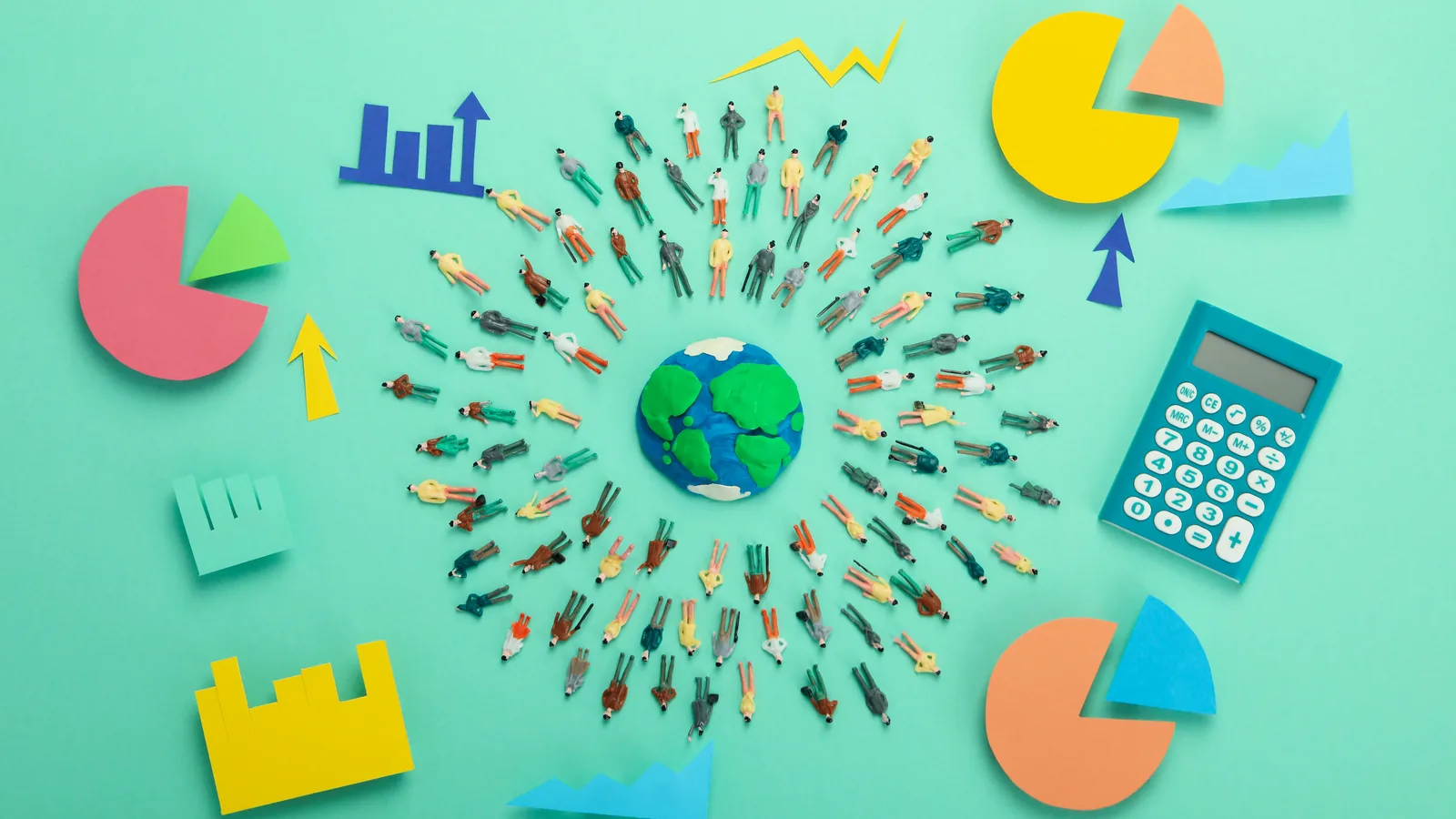 Paper cut-outs of charts, arrows, and a globe arranged on a green background.