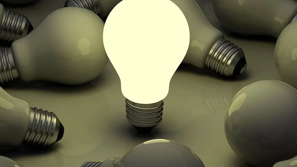 A single lit bulb among many unlit ones.